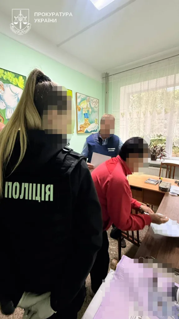 Поліцейська та слідчі проводять дії в кабінеті