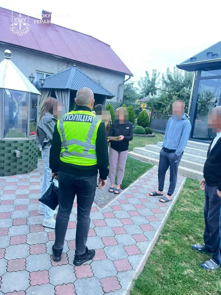Поліцейський спілкується з людьми біля приватного будинку