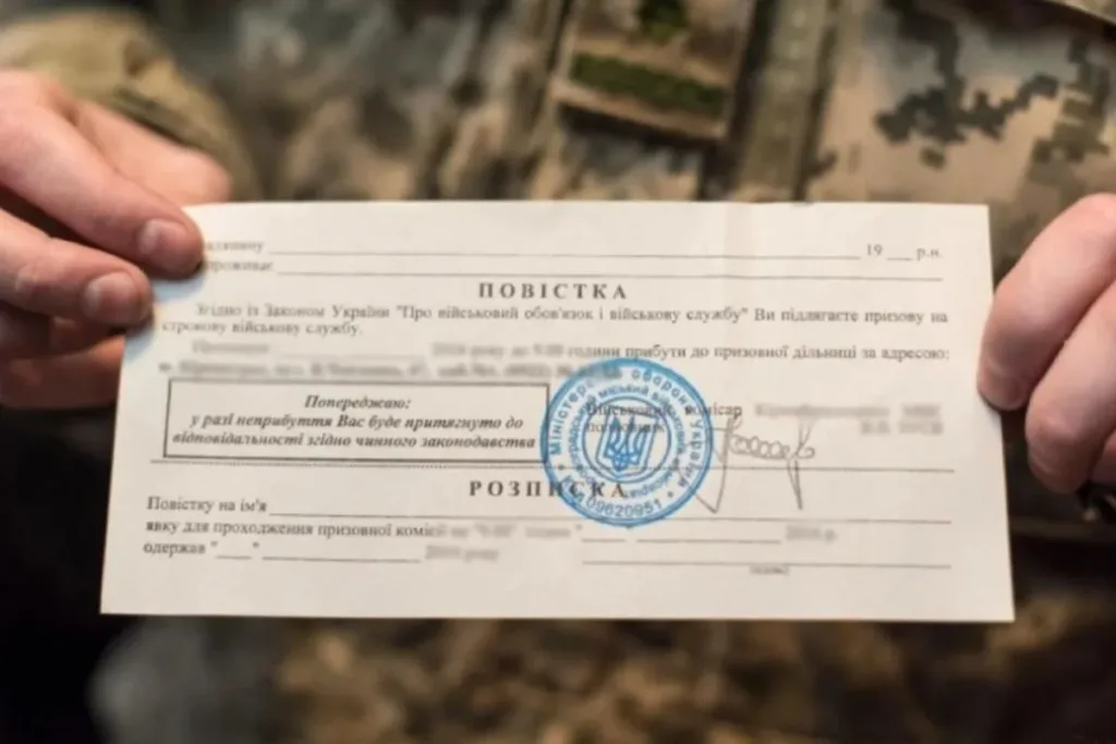 Військовослужбовець тримає українську повістку з печаткою