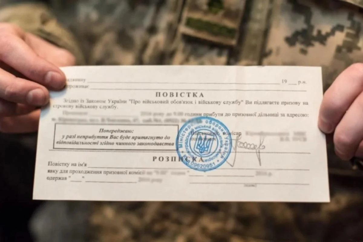 Військовослужбовець тримає українську повістку з печаткою