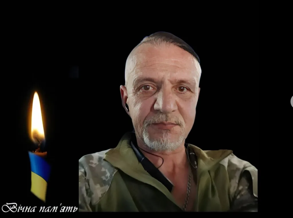 Портрет військового поруч зі свічкою в кольорах України