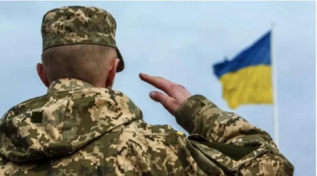 Український військовий віддає честь державному прапору