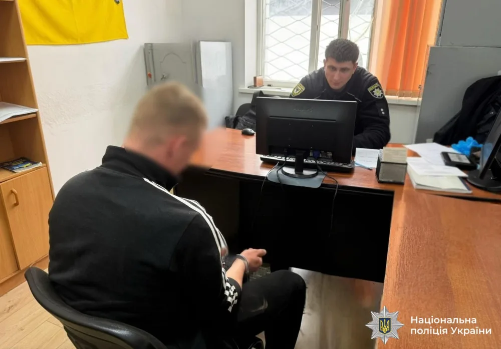 Поліцейський спілкується із затриманим у службовому кабінеті