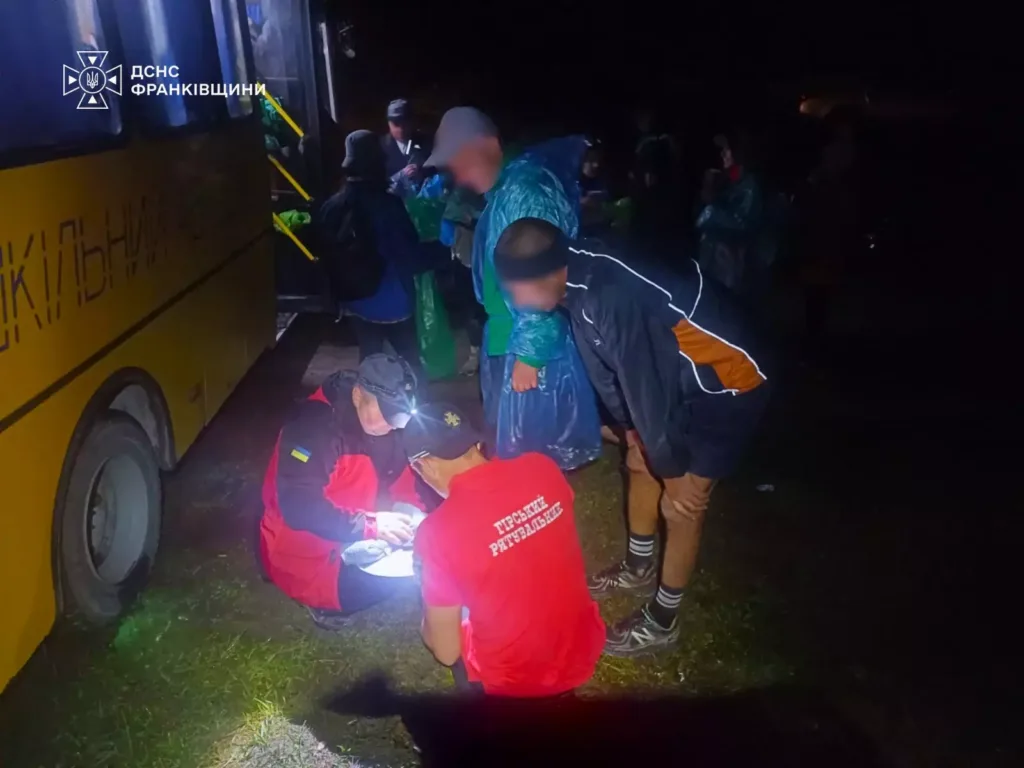 Рятувальники надають допомогу людям біля автобуса вночі