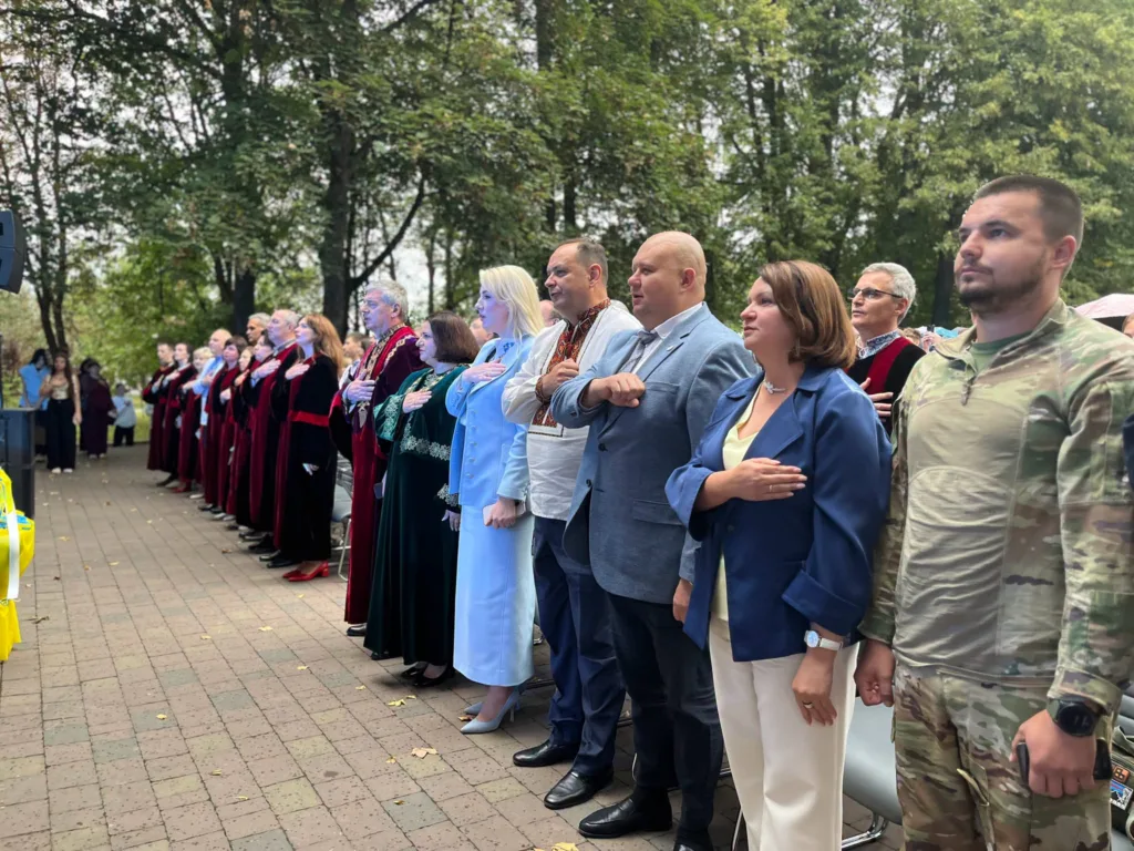 Учасники урочистості стоять із руками на серці