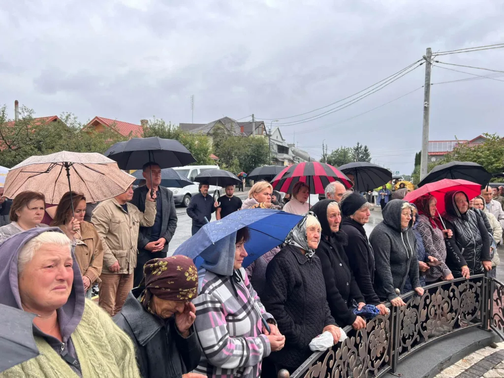 Люди з парасолями зібралися під дощем