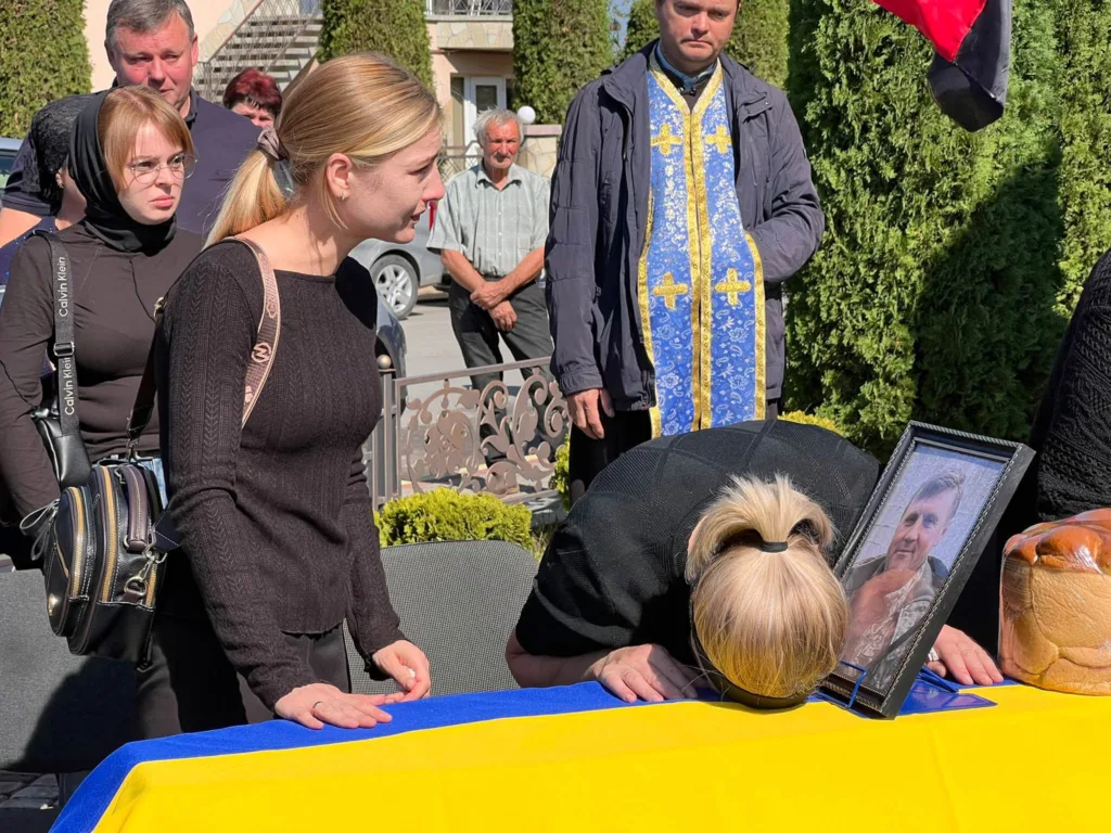 Прощання біля труни, вкритої українським прапором
