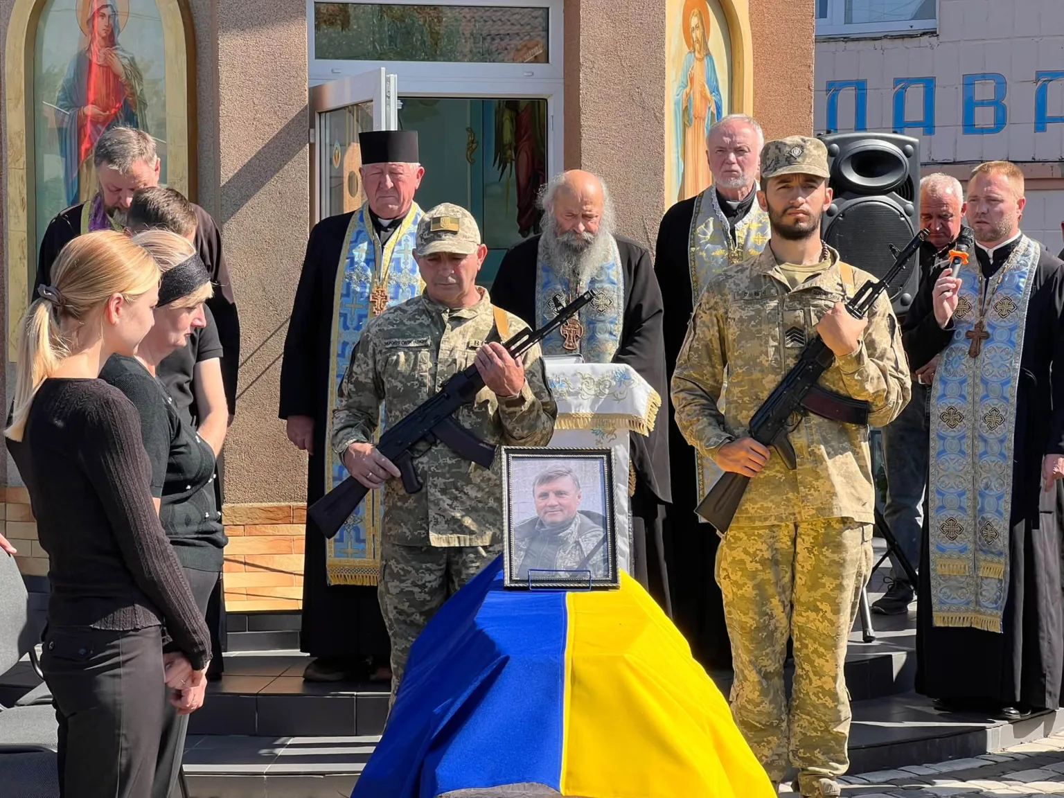 Прощання з військовим біля церкви під українським прапором