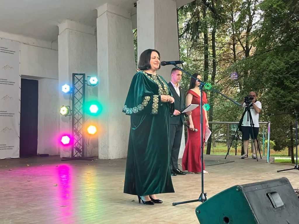 Жінка у зеленій мантії виступає на сцені