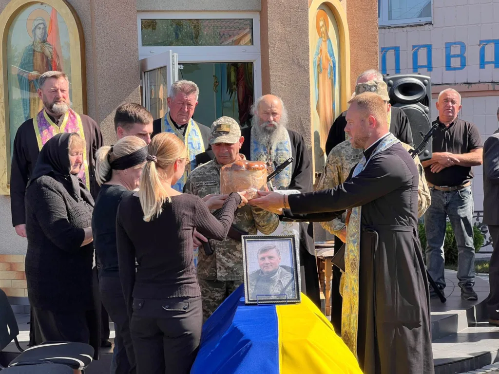 Прощання з військовим біля церкви під українським прапором
