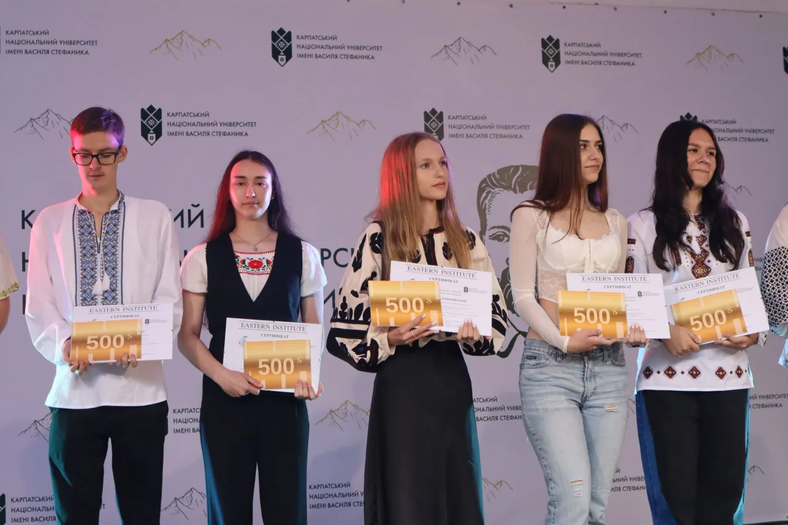 Студенти з сертифікатами на 500 доларів на сцені