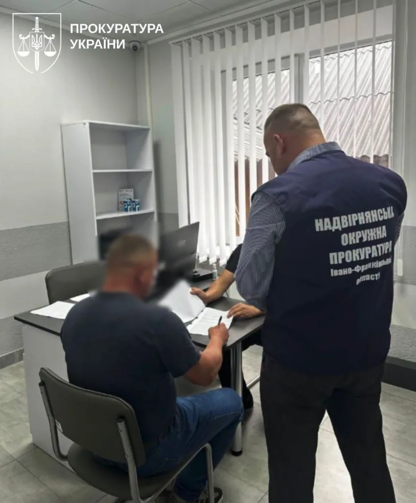 Працівник прокуратури оформлює документи з чоловіком в офісі