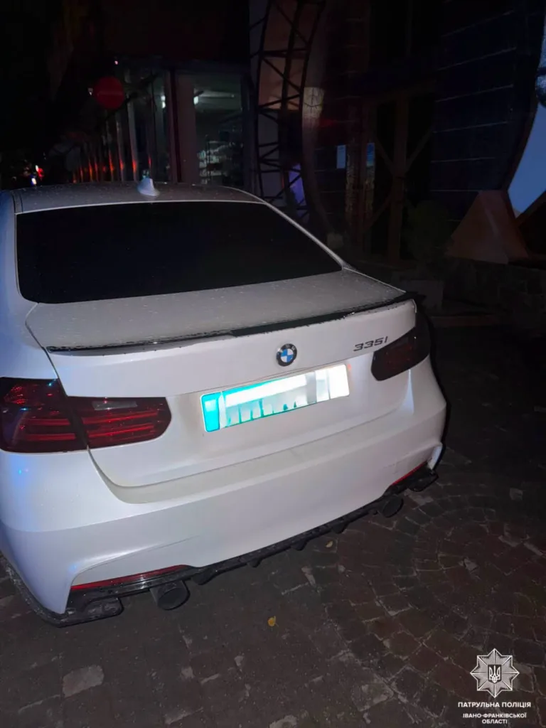 Білий BMW 335i з пошкодженим заднім склом уночі