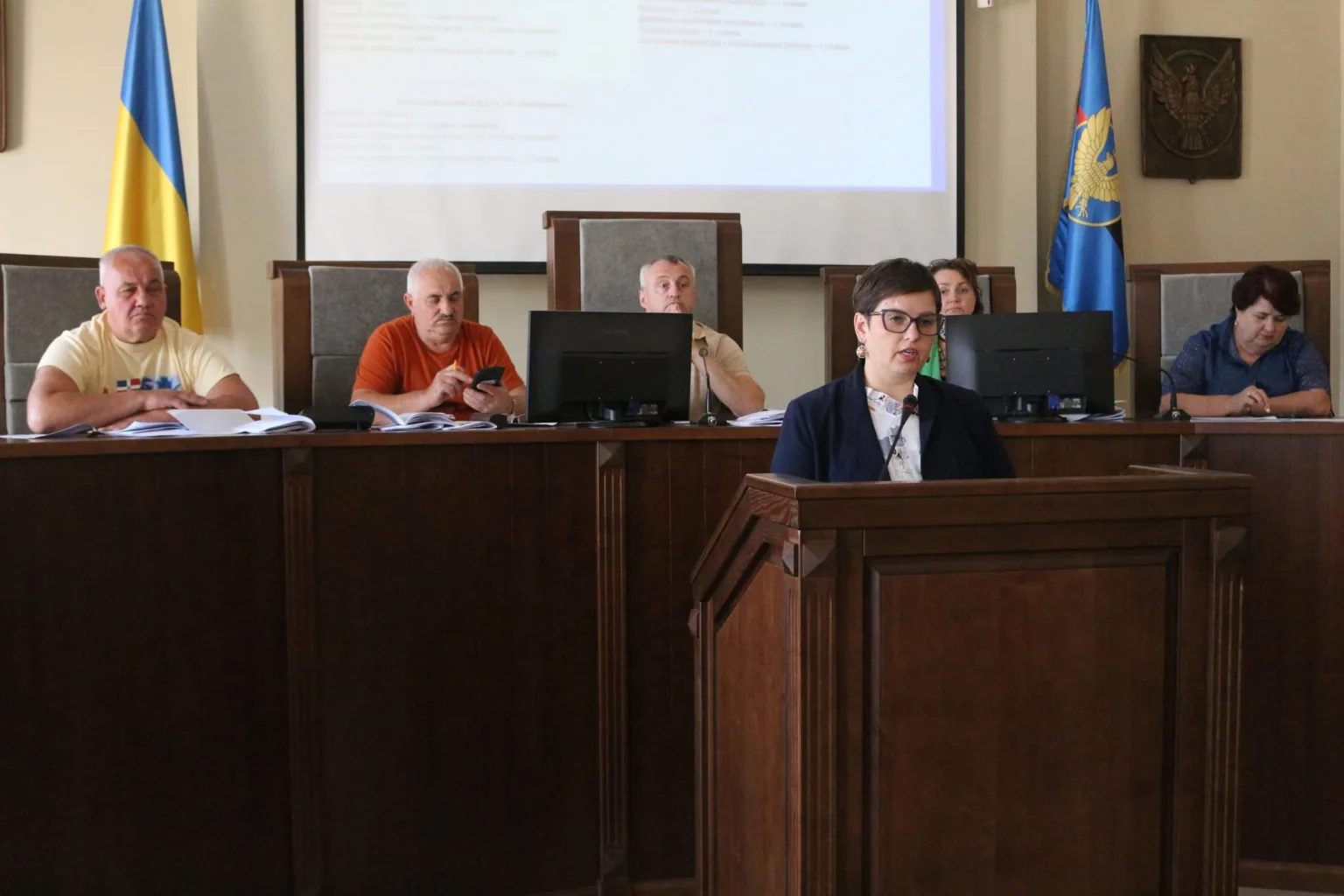 Жінка виступає на засіданні перед представниками установи