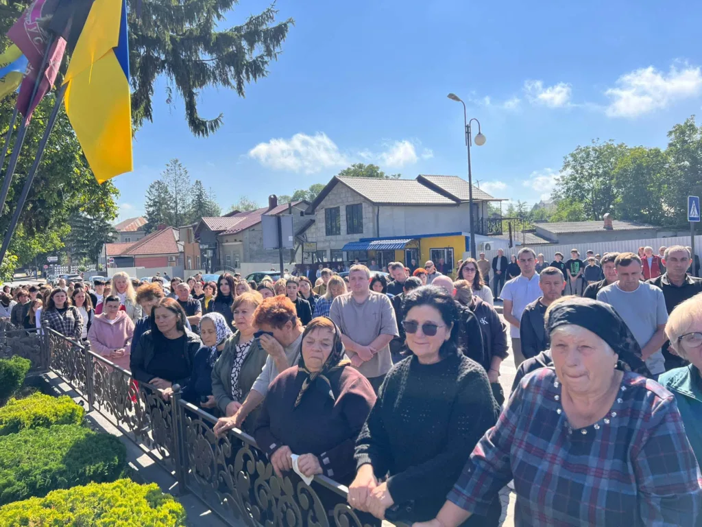 Люди зібралися біля українських прапорів у сонячний день