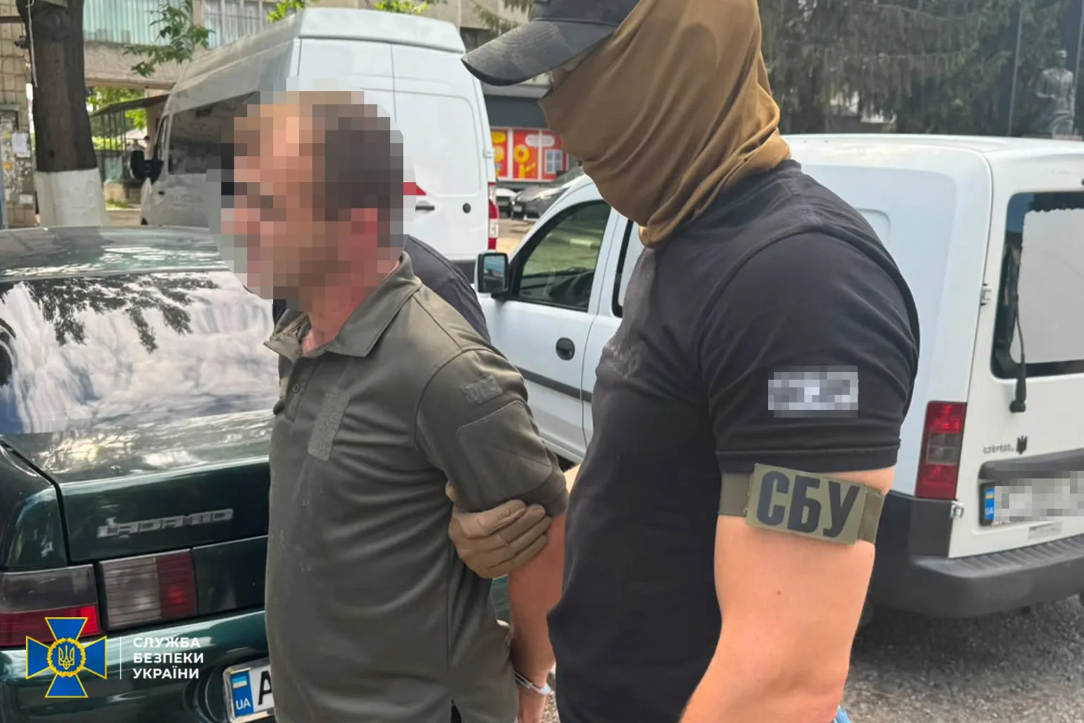 Співробітник СБУ затримує чоловіка біля автомобілів