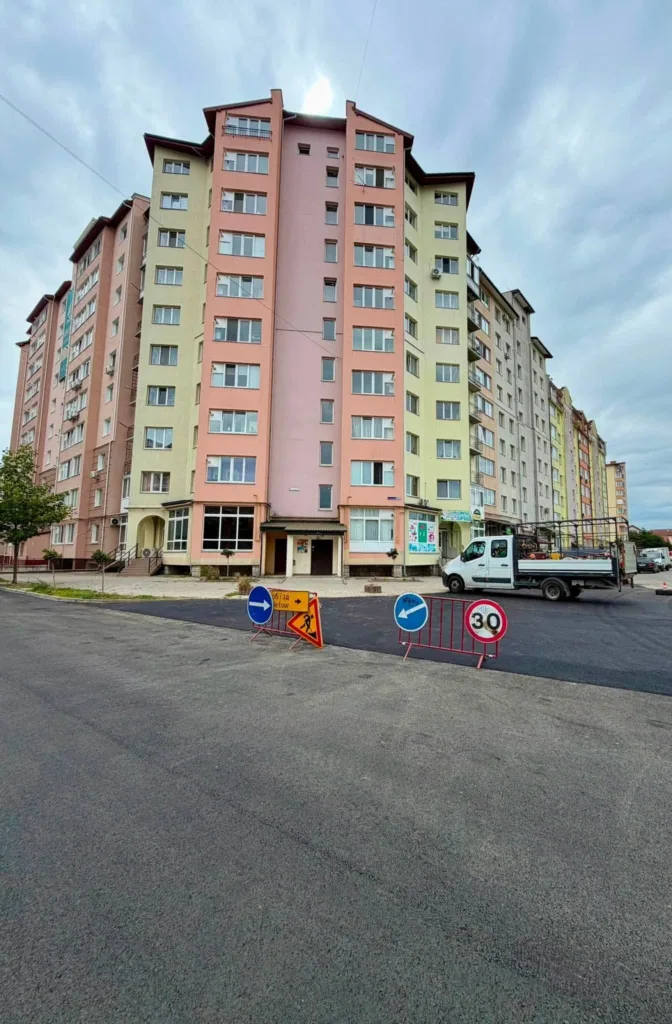 Кольоровий багатоповерховий житловий будинок біля дорожніх робіт