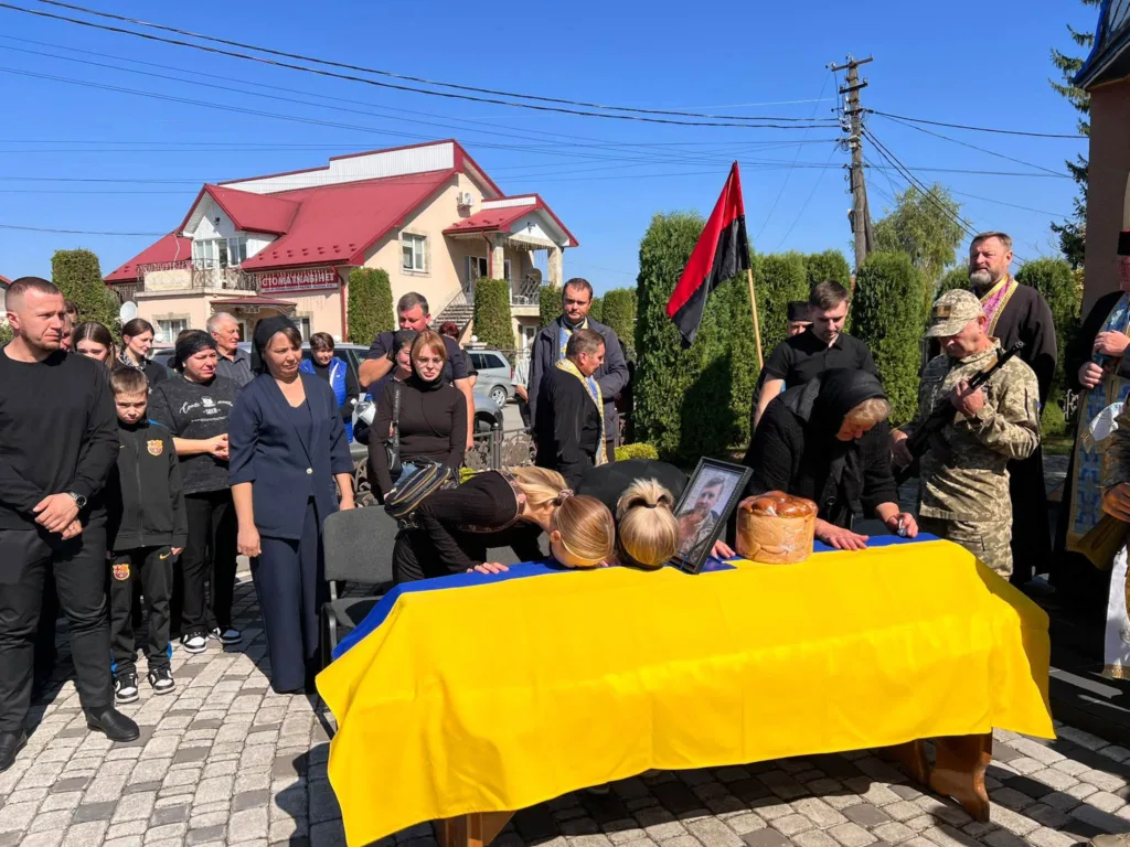 Прощання із військовим біля труни, вкритої прапором України
