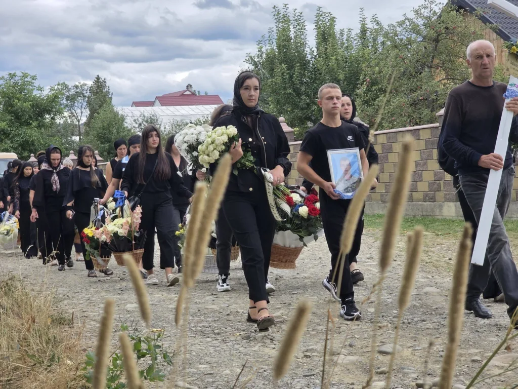 Жалобна процесія з квітами та портретом померлого