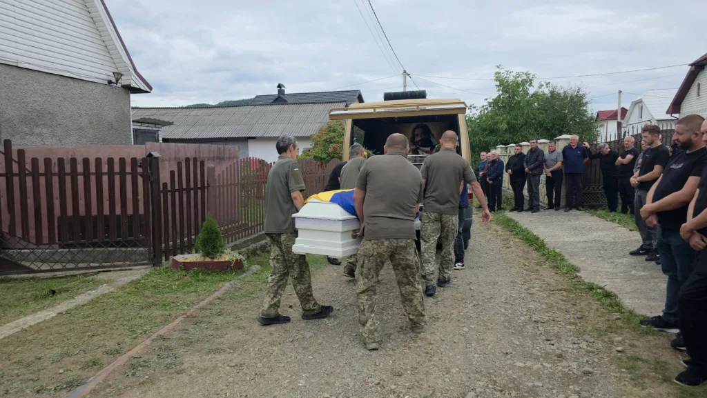 Військові несуть труну з українським прапором до катафалка