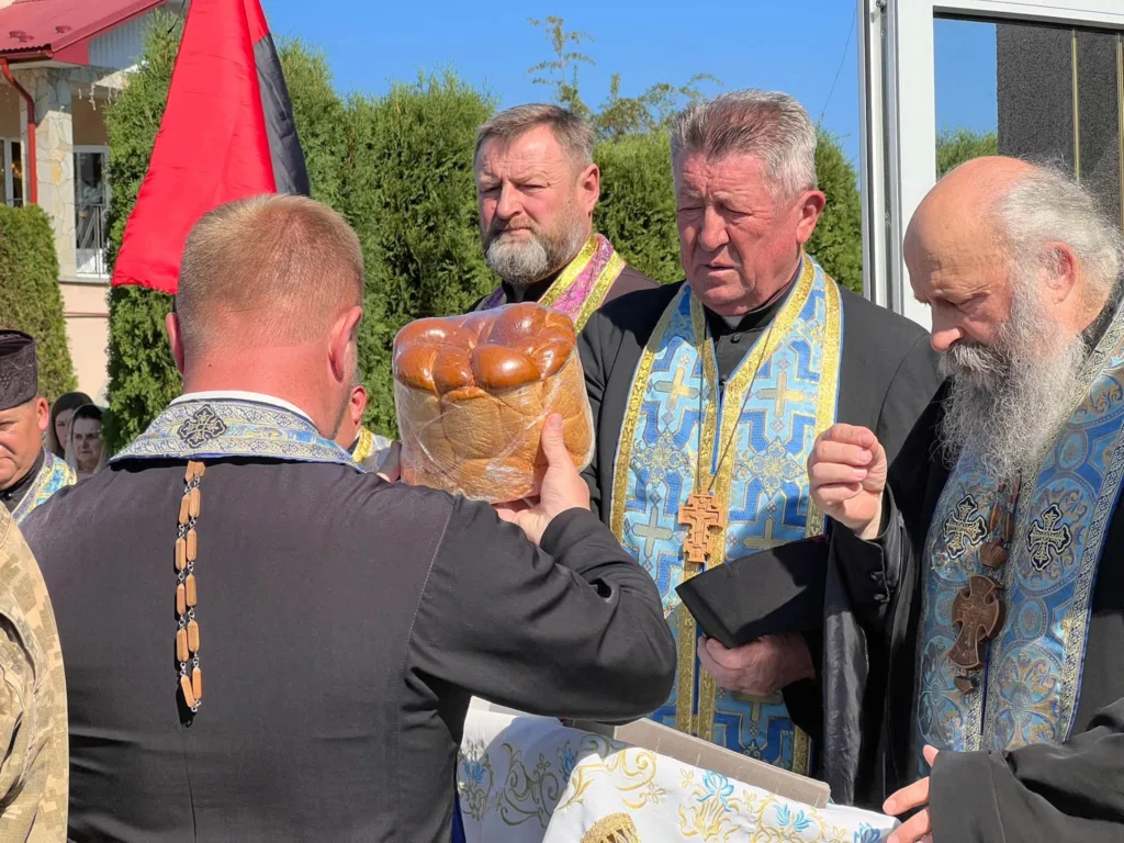 Священники освячують хліб під червоно-чорним прапором