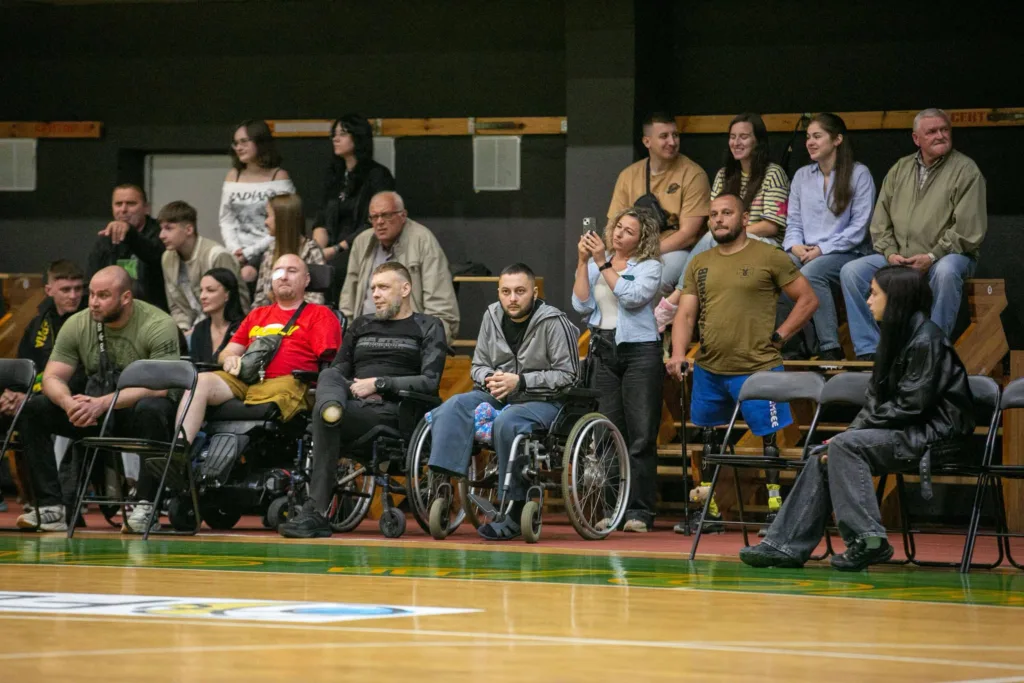Глядачі, зокрема люди на візках, у спортивній залі