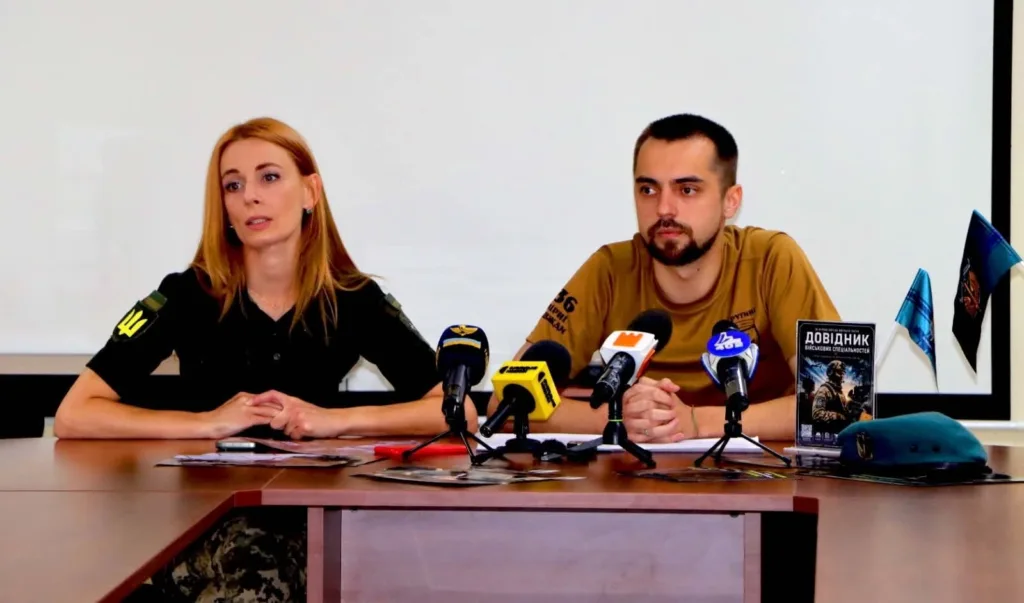 Двоє військових представників на пресконференції з мікрофонами