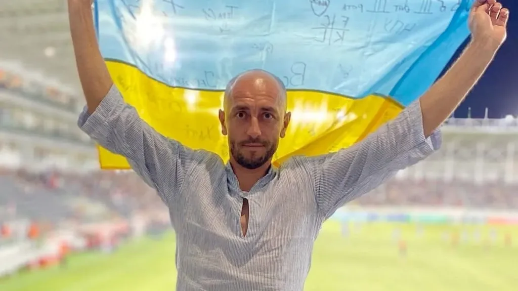 Чоловік тримає український прапор на футбольному стадіоні