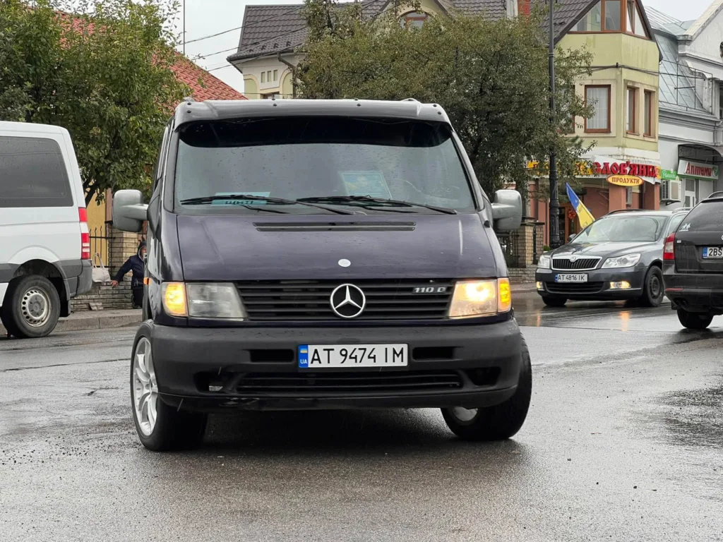 Темний мікроавтобус Mercedes на мокрій міській вулиці