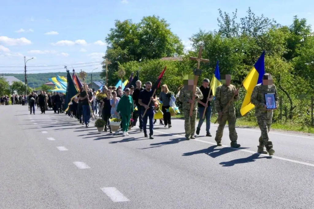 Жалобна хода з українськими прапорами та портретом військового