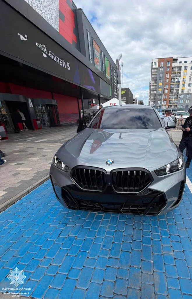 Сірий BMW припаркований на синій бруківці біля торгового центру