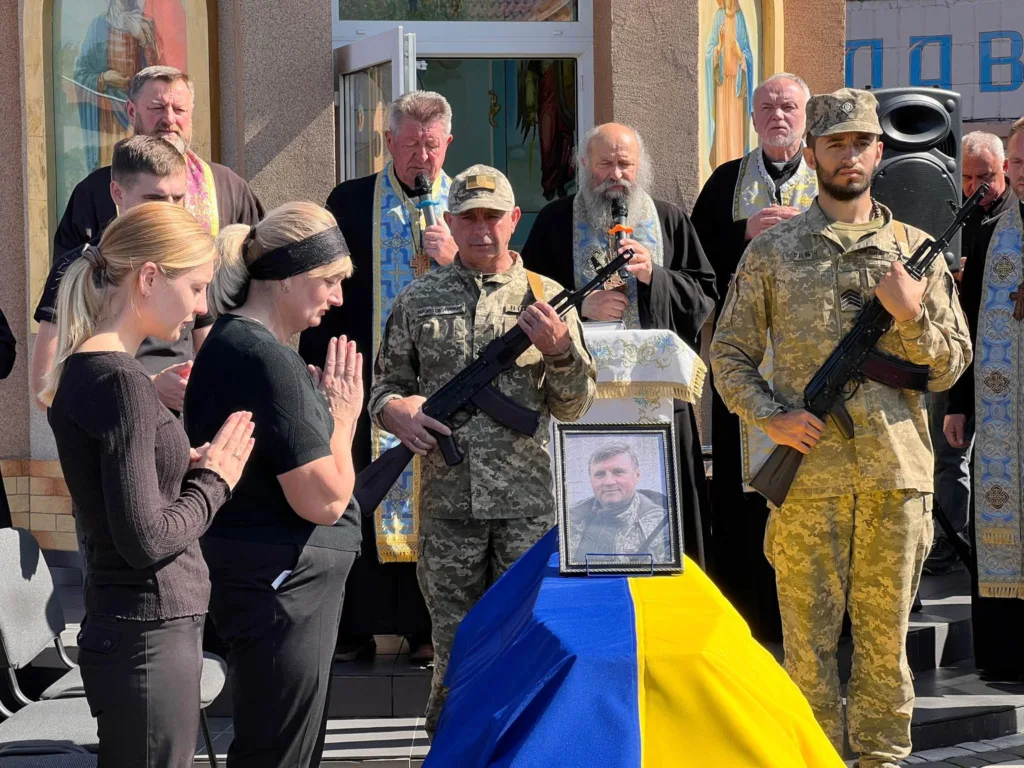 Прощання з військовим біля церкви під українським прапором