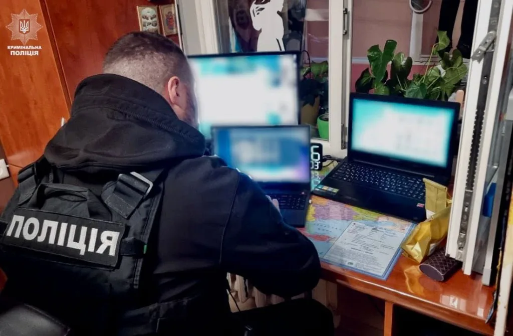 Поліцейський працює за комп’ютерами під час обшуку