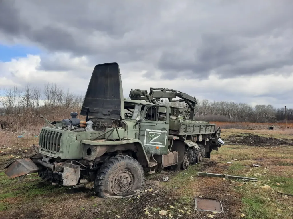 Пошкоджена військова вантажівка з краном у полі