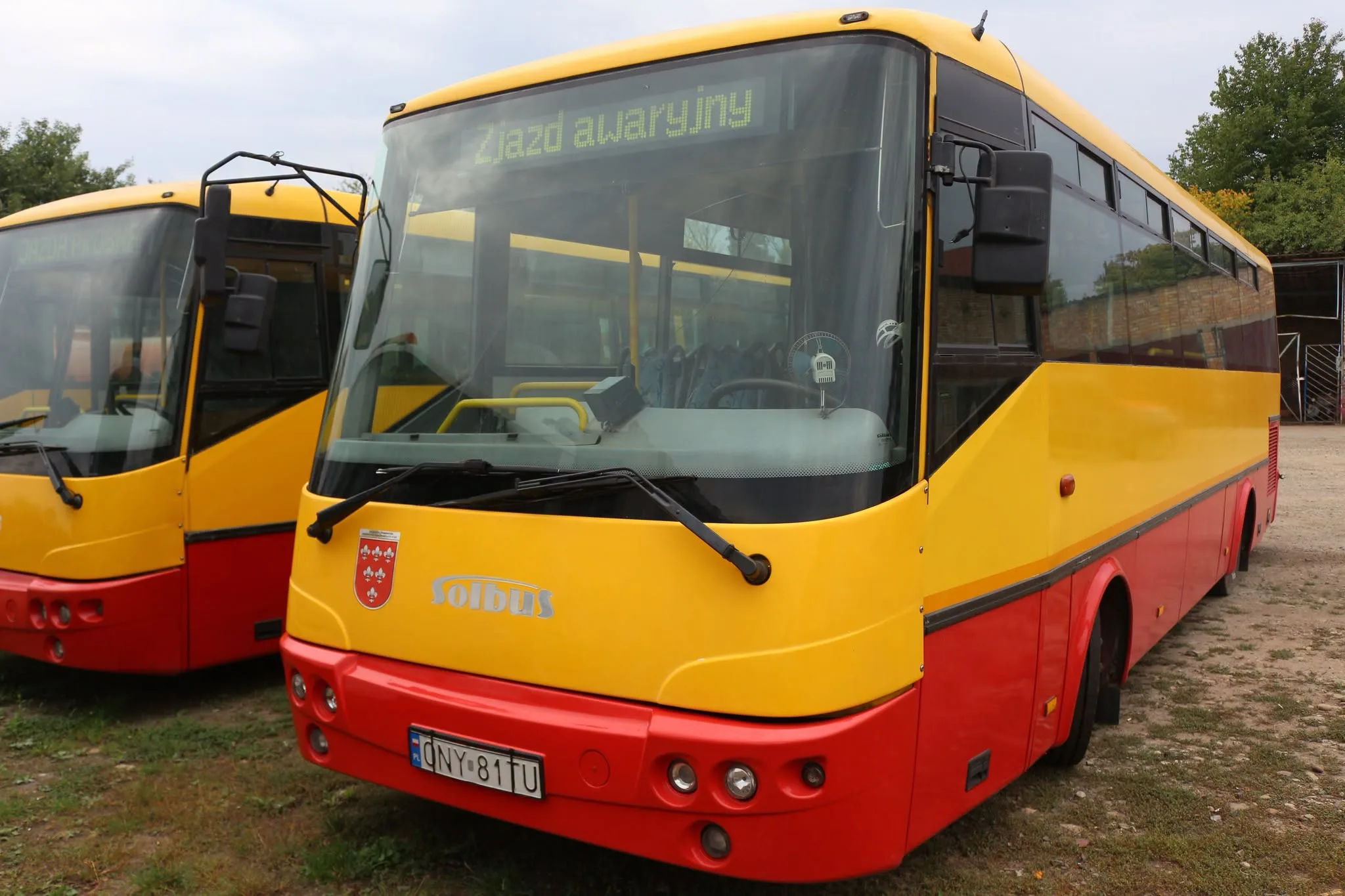 Жовто-червоні міські автобуси стоять на майданчику