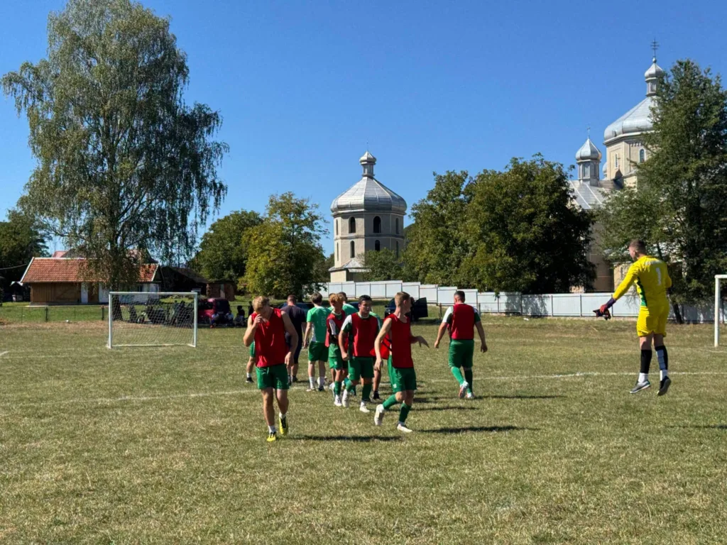 Футболісти на полі біля церкви