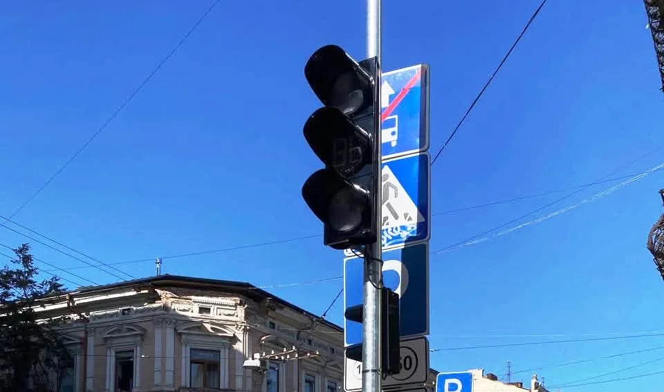 Світлофор і дорожні знаки на тлі історичної будівлі