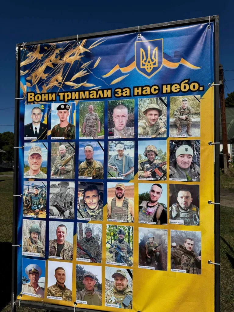 Стенд пам’яті українських військових із фотографіями та тризубом