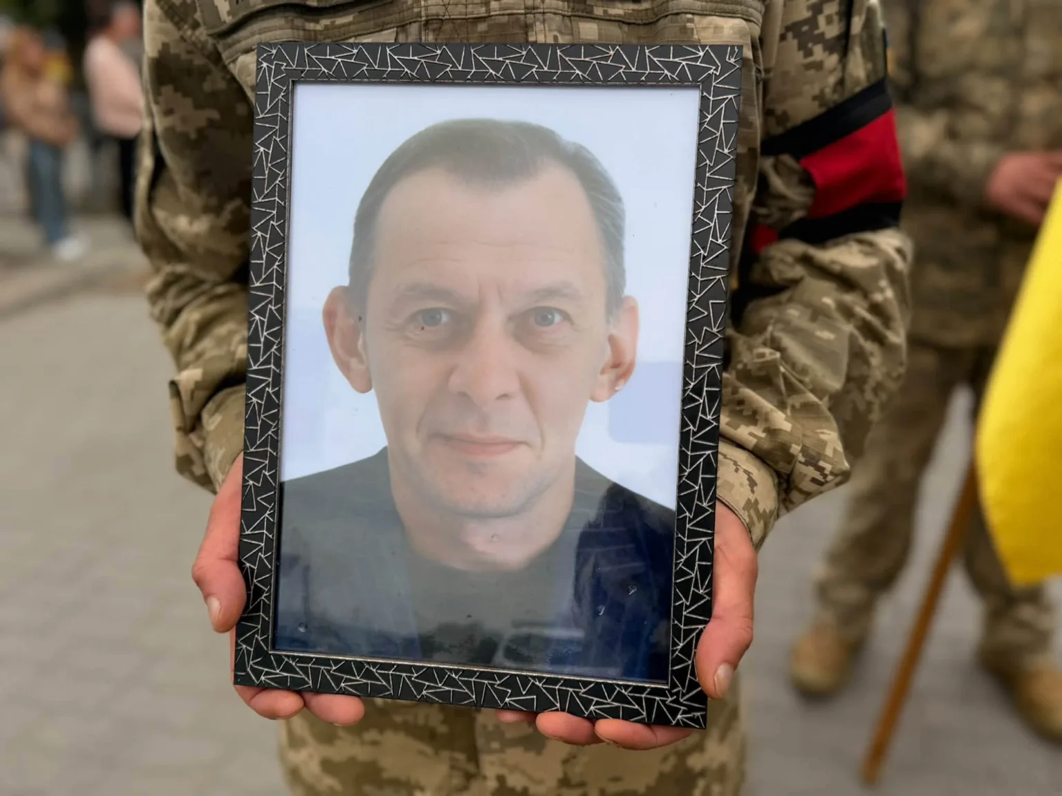 Військовий тримає портрет чоловіка в рамці