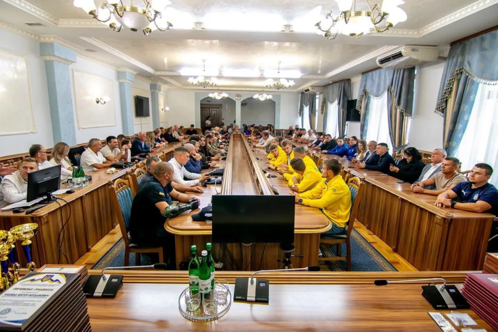 Нарада за довгими столами за участю спортсменів у жовтому