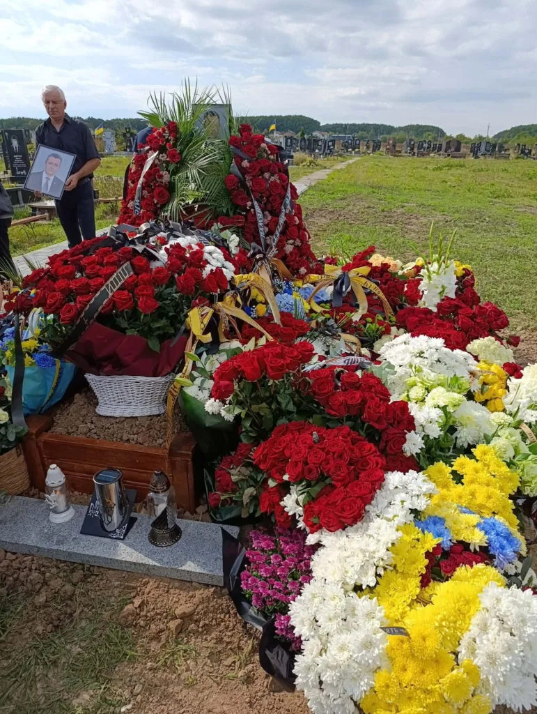 Могила, вкрита квітами, на кладовищі