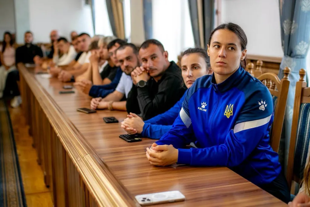 Спортсмени збірної України сидять за столом на зустрічі