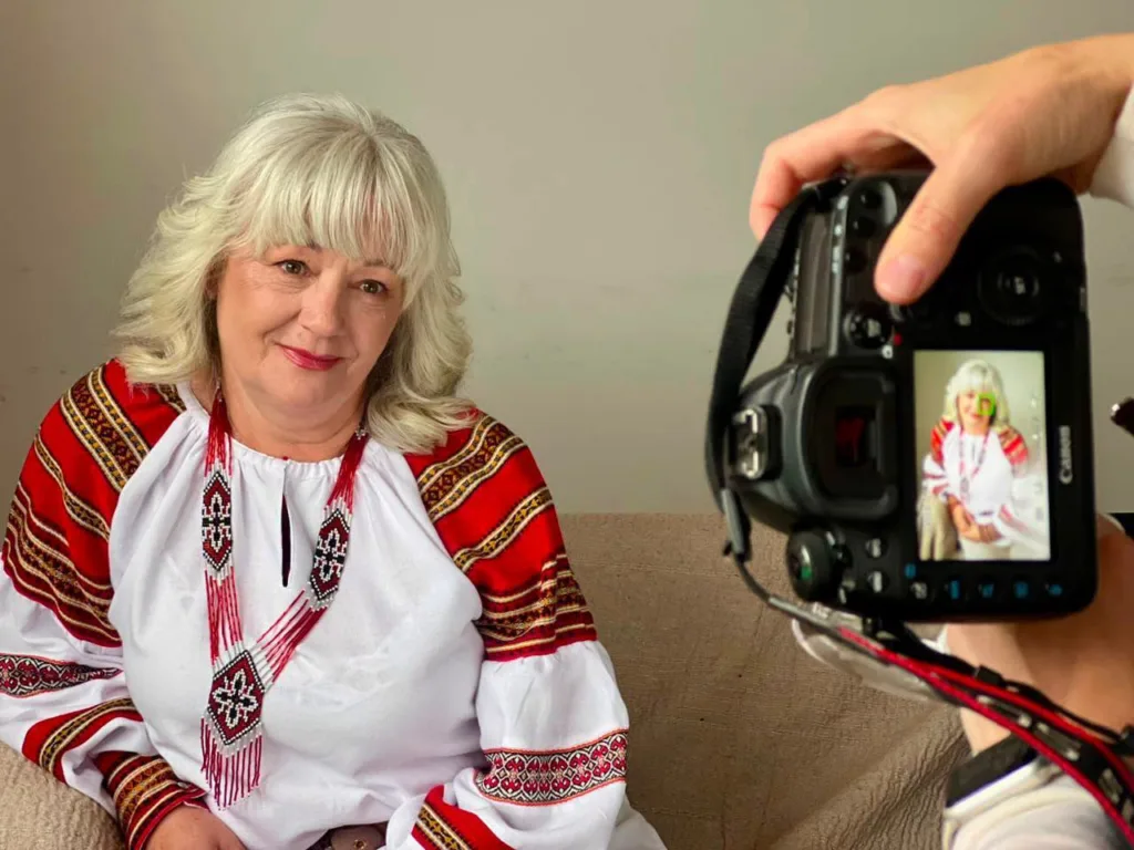 Жінка у вишиванці позує перед фотоапаратом