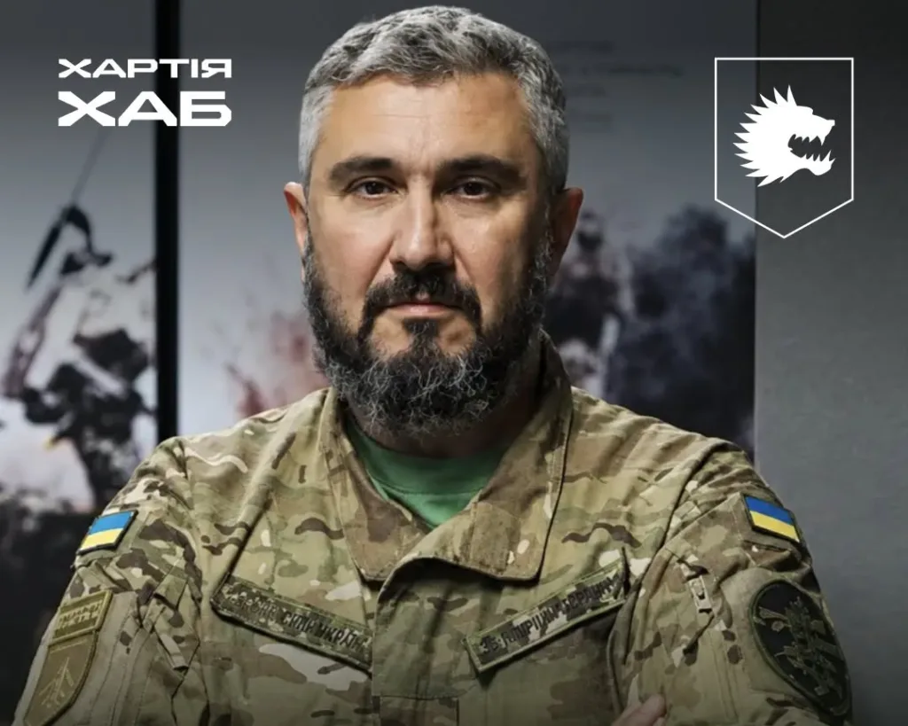 Військовий у камуфляжі на тлі логотипів «Хартія ХАБ»