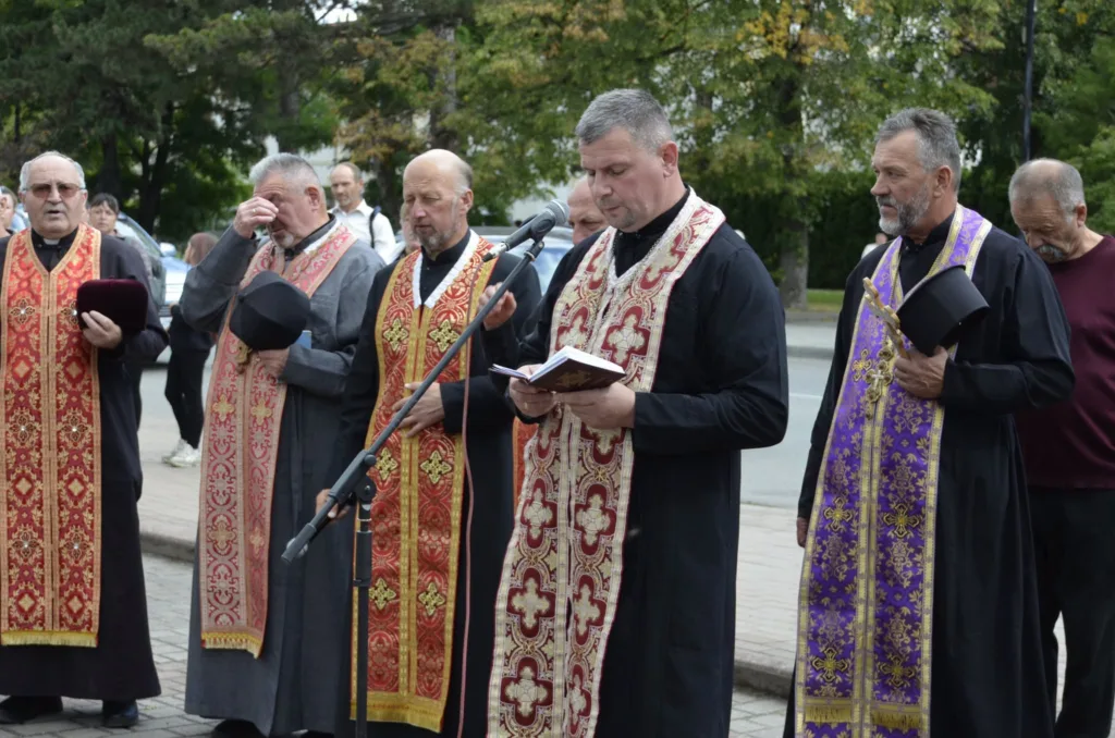 Священники моляться на відкритому богослужінні біля мікрофона