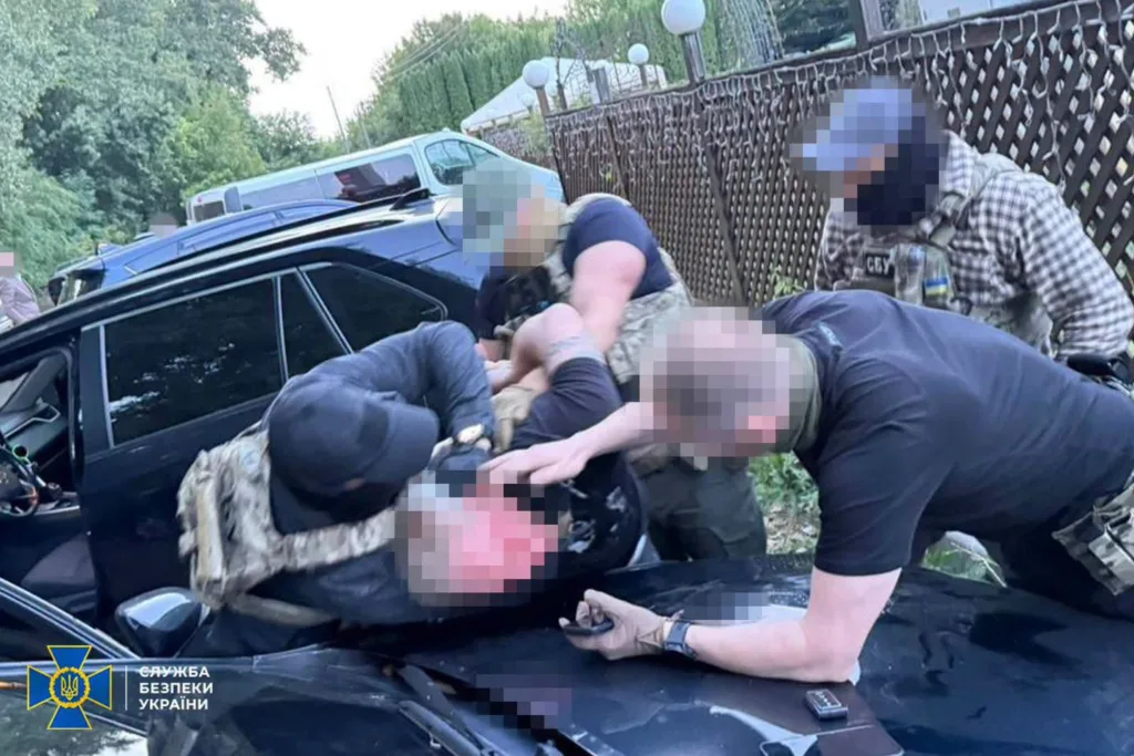 Працівники СБУ затримують чоловіка біля автомобіля