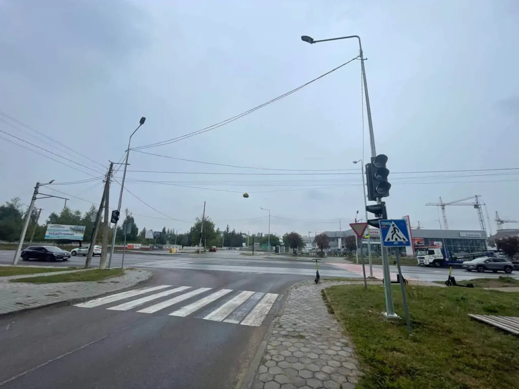 Мокре перехрестя зі світлофорами та пішохідними переходами