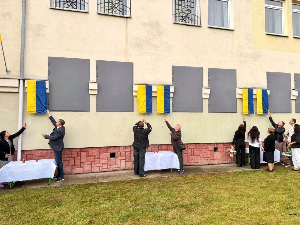 Люди відкривають меморіальні дошки на фасаді будівлі