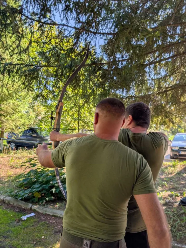 Двоє чоловіків тренуються стрільби з лука