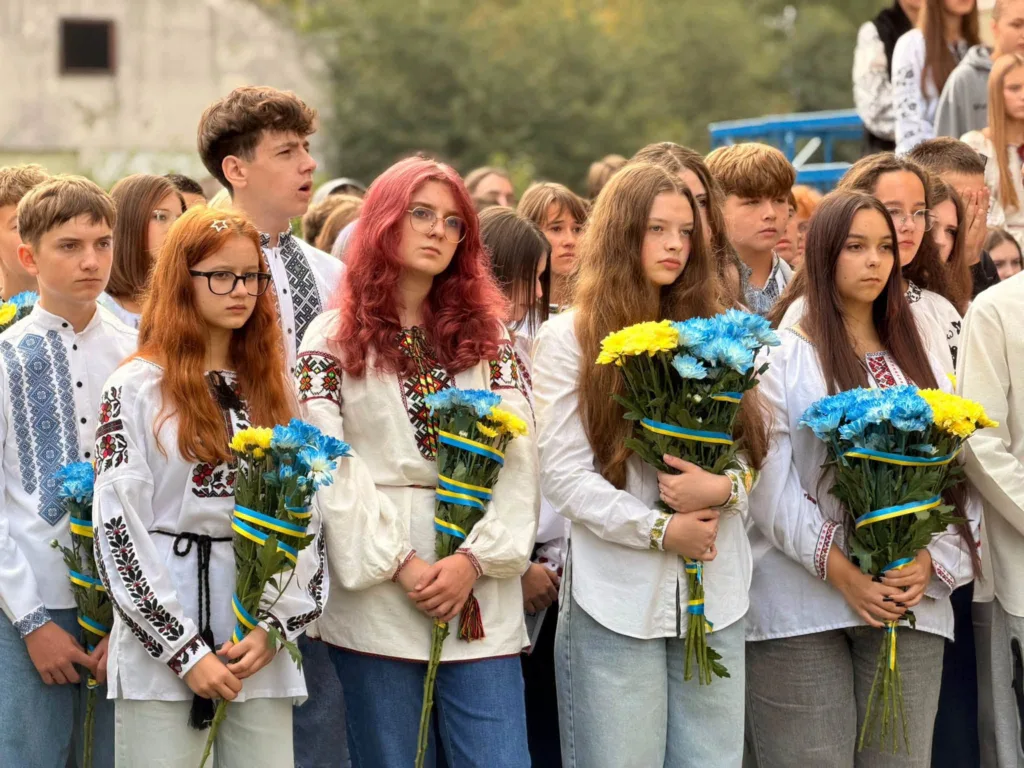 Учні у вишиванках тримають синьо-жовті букети